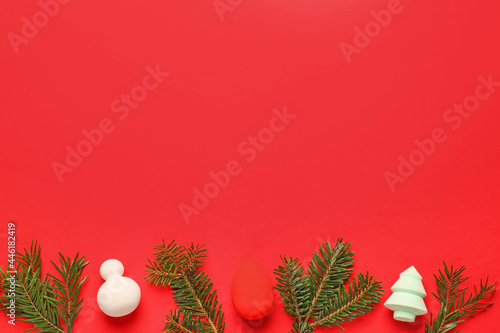 Christmas tree branches with makeup sponges on color background