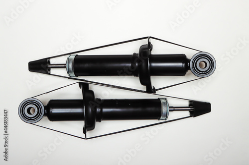 Two new shock absorbers for the car lie on a flat surface. A set of spare parts for the repair of the chassis of the vehicle. Details on white background, copy space available. UHD 4K. photo