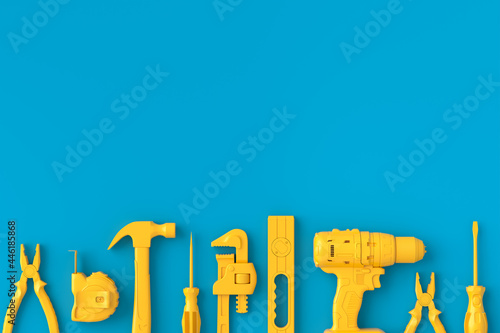 Top view of monochrome construction tools for repair on blue and yellow photo