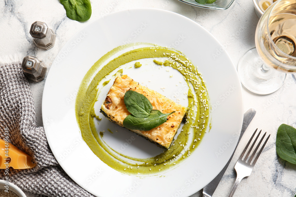 Plate with tasty green lasagna on light background Plate with tasty green lasagna on light background