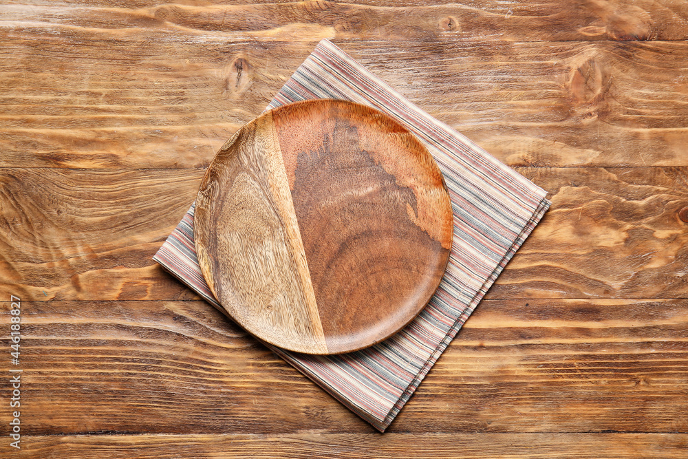 Fototapeta premium Fabric napkin and plate on wooden background