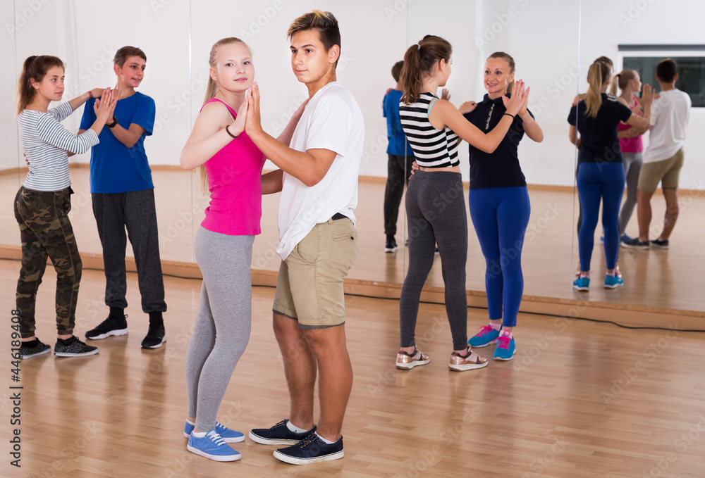 Obraz premium Smiling schoolchildren dancing rumba in training