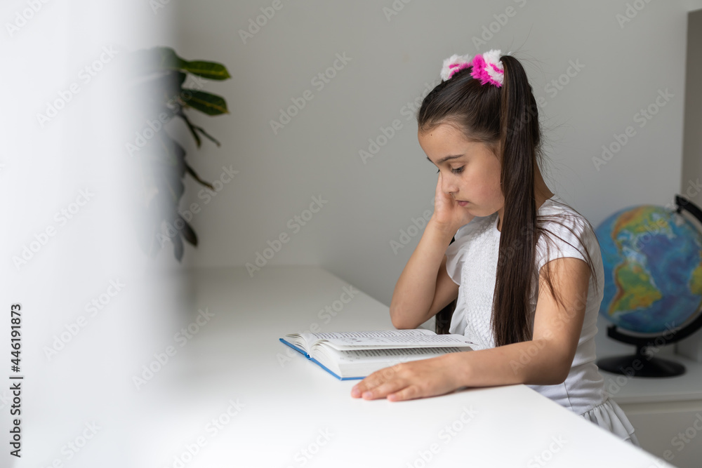 Cheerful little girl laughing and reading book over white. Cheerful little girl laughing and reading book over white.