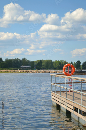 Pier on the lake with a flotation ring  in sunny summer day. Closeup. Vertical view.  