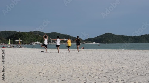 Four young people males exercising on the beach on Langkawi island Malaysia