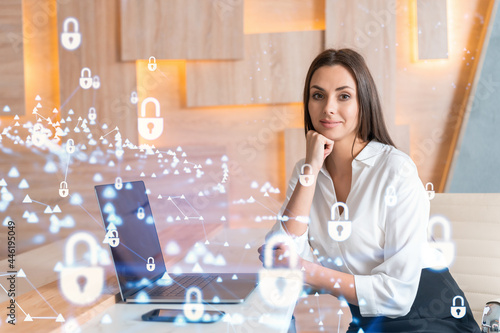 Fotografia Attractive businesswoman in white shirt at workplace working with laptop to defend customer cyber security