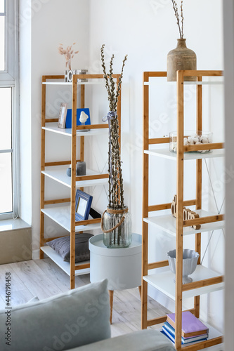 Vase with willow branches in interior of room