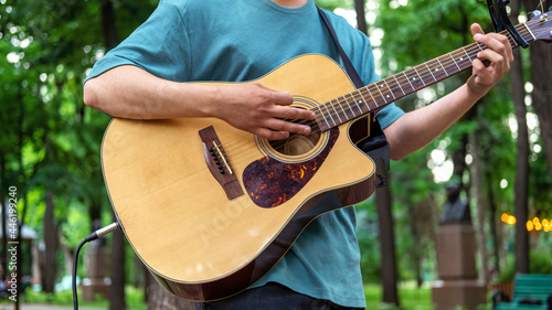 Man playing guitar outdoors in a park