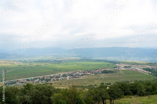 Summer valley landscape with road  cypresses and mountains in Crimea. Photo of small village located among mountains.
