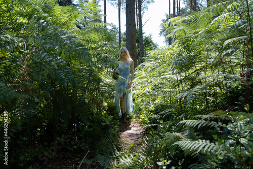 Beautiful woman walking through ferns