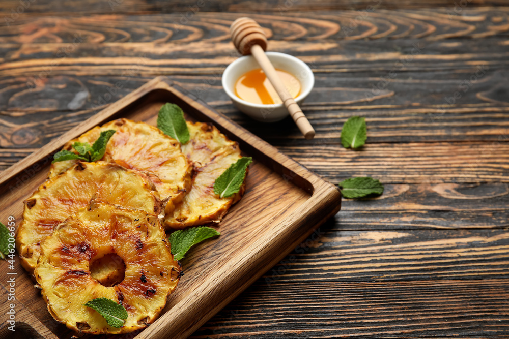 Board with grilled pineapple slices and honey on wooden background, closeup Board with grilled pineapple slices and honey on wooden background, closeup