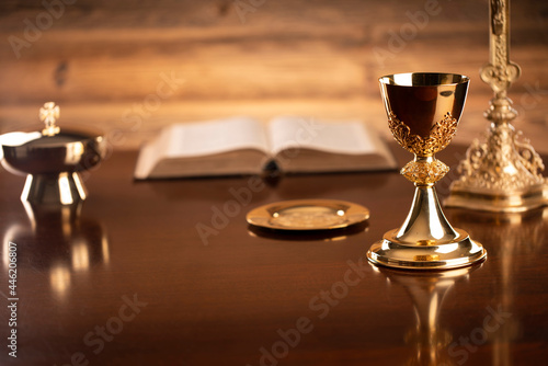 Catholic religion concept. Catholic symbols composition. The Cross, monstrance, Holy Bible and golden chalice on brown background. 