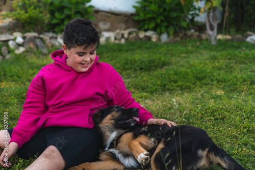 Niño jugando con un perro de raza pastor alemán en el jardín