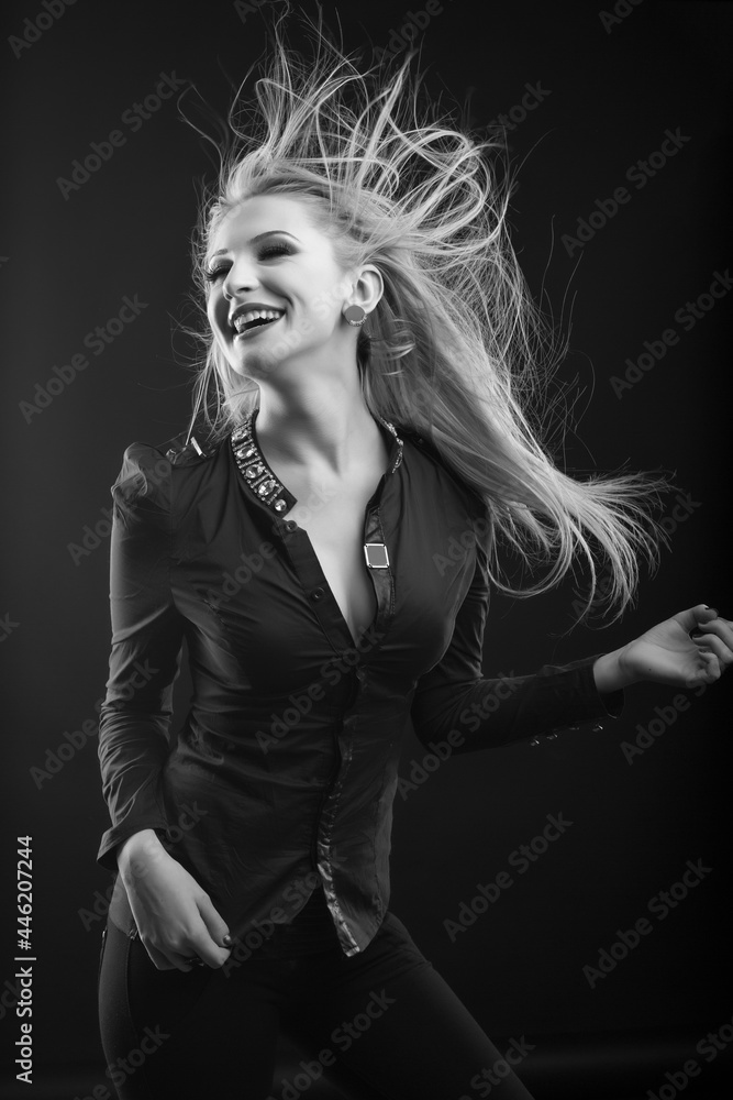 Cheerful blond woman with long fluttering hair posing at studio Cheerful blond woman with long fluttering hair posing at studio