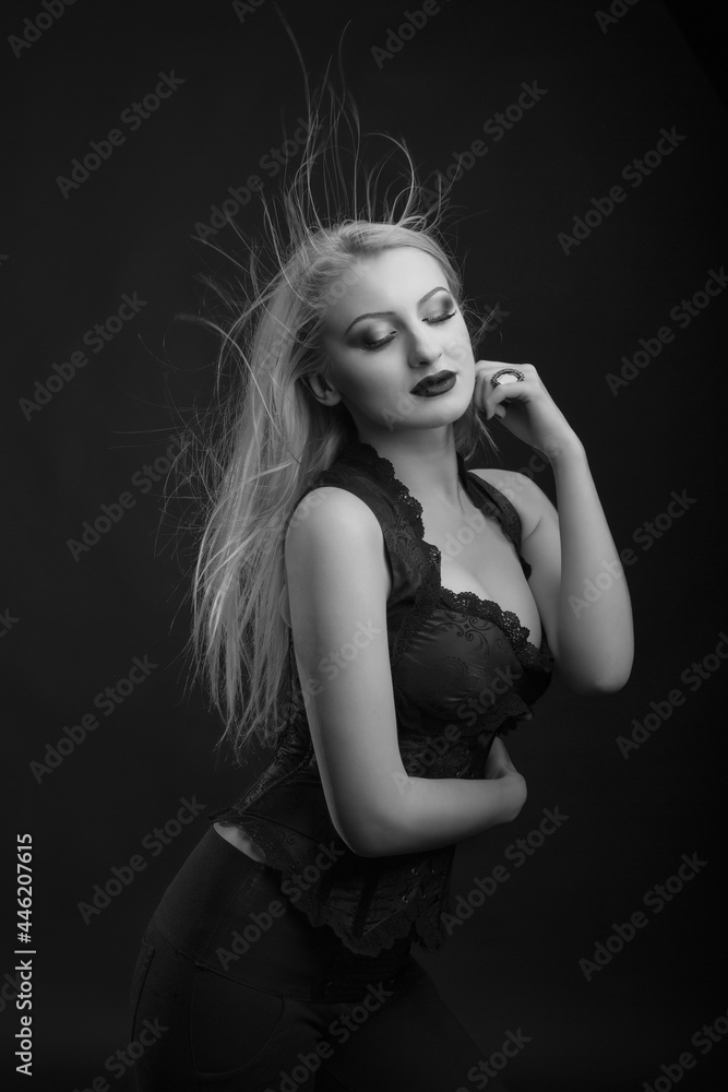 Naklejka premium Seductive woman with bright makeup and hair in wind wears corset