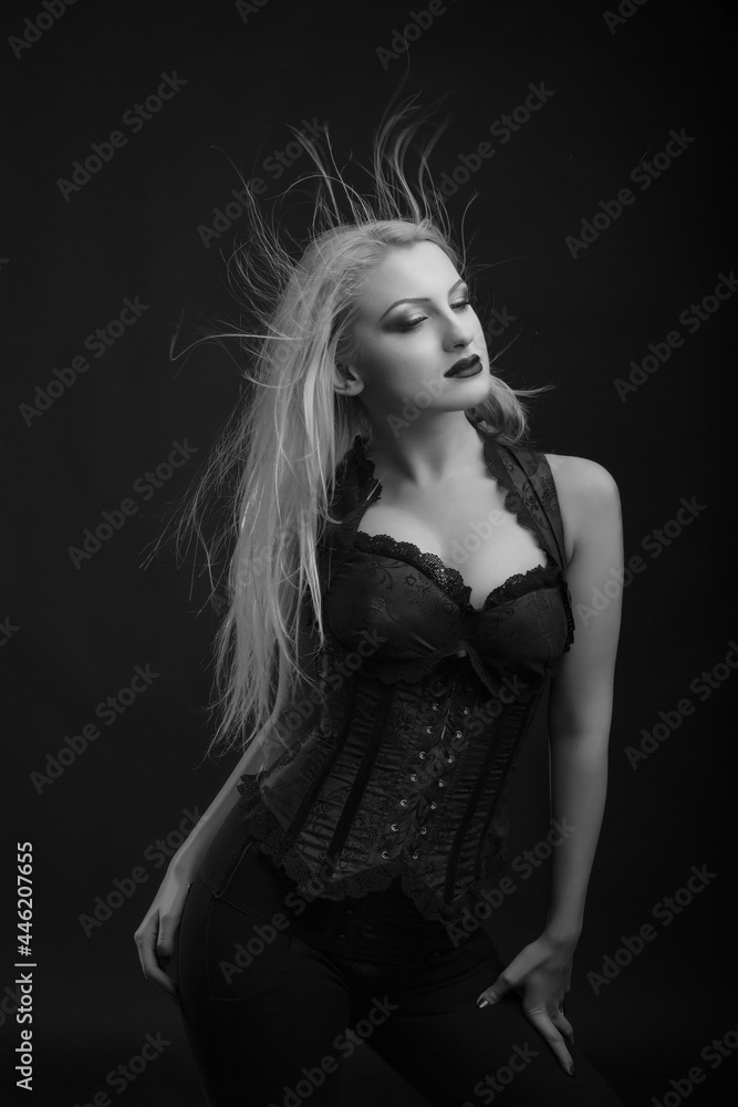Naklejka premium Sensual woman with bright makeup and hair in wind wears corset