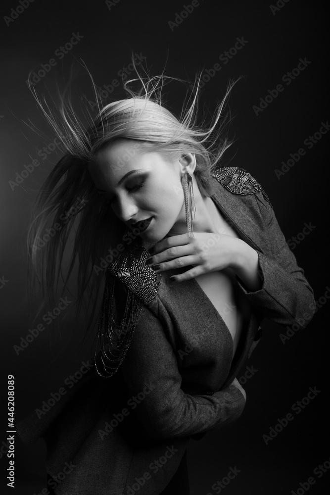 Sensual woman with bright makeup and hair in wind wears jacket Sensual woman with bright makeup and hair in wind wears jacket