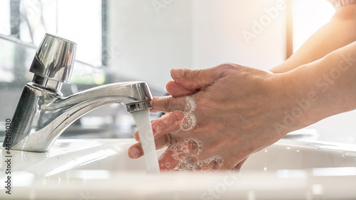 Hand washing rubbing with antibacteria liquid soap for disinfection, covid-19 protection, corona virus prevention and hygiene to stop spreading coronavirus by using tap water and sanitizer at sink photo