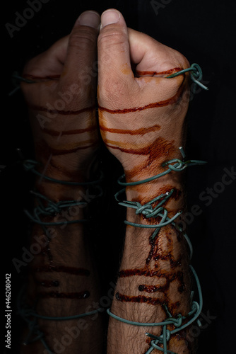 bloody hand with barbed wire symbolizing oppression during lockdown © cosmoerik