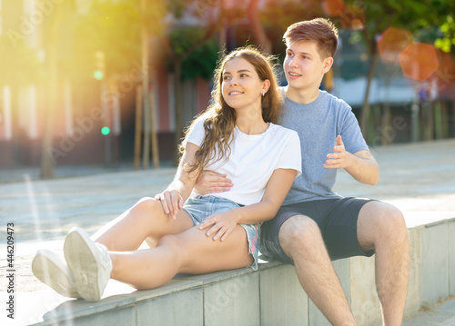 A couple of young people is sitting on the step