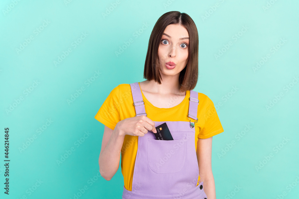 Photo of young amazed shocked woman hold hands credit card sale put pocket isolated on teal color background Photo of young amazed shocked woman hold hands credit card sale put pocket isolated on teal color background