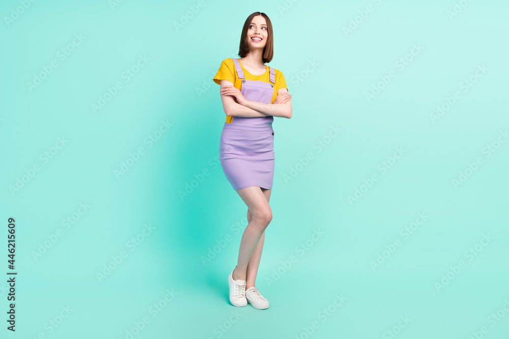 Full length photo of charming confident happy woman look empty space crossed hands isolated on teal color background Full length photo of charming confident happy woman look empty space crossed hands isolated on teal color background