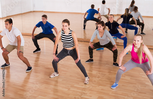 Group of teenage students with trainer stretching at dance class