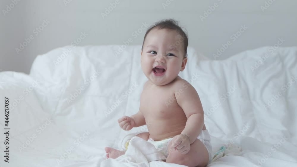 portrait of asian baby infant 6 months old naked after bathing covered with white towel. happy innocence baby kid smile happily. sucking hand age baby portrait copy space provided. smiling baby laugh. portrait of asian baby infant 6 months old naked after bathing covered with white towel. happy innocence baby kid smile happily. sucking hand age baby portrait copy space provided. smiling baby laugh.