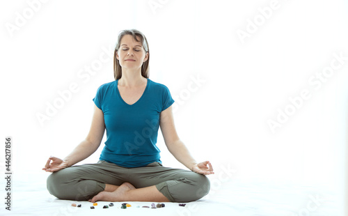 Middle aged woman meditating with crystals photo