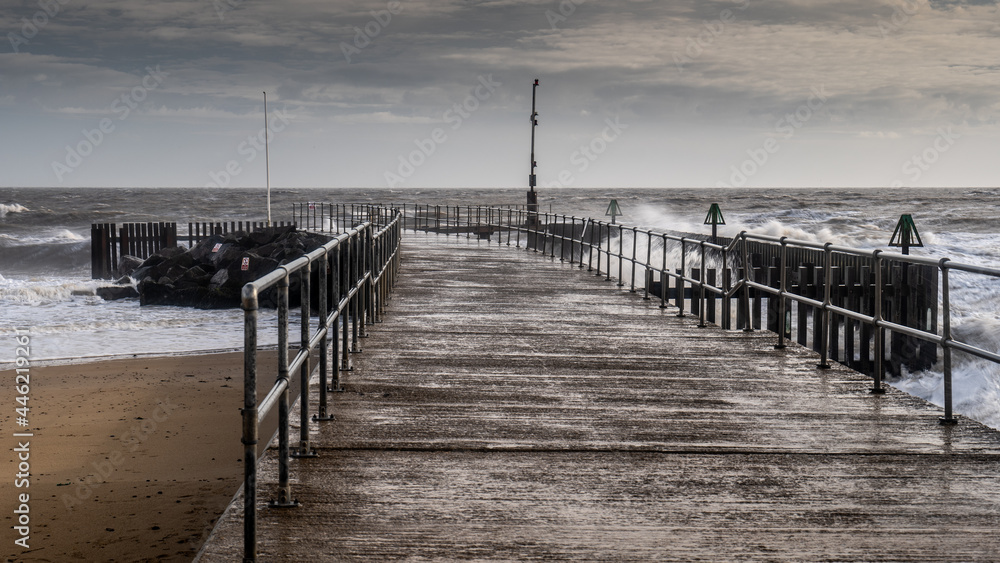 Stormy sea and windswept jetty during a storm  in Suffolk Uk