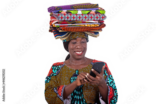 beautiful woman with traditional loincloths on her head using a mobile phone while smiling.