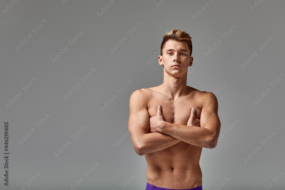 Young swimmer in excellent physical shape, on a gray background with copy space, call for sports, advertising banner Young swimmer in excellent physical shape, on a gray background with copy space, call for sports, advertising banner