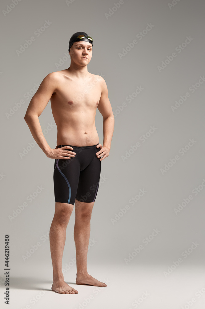 Young swimmer in excellent physical shape in full growth on a gray background with copy space, call for sports, advertising banner