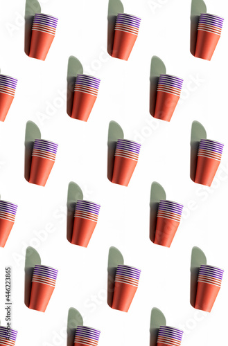 Cups pattern background. Takeaway drink. Summer party. Ecology problem. Set of red purple colorful minimalist disposable paper mugs isolated on white surface.