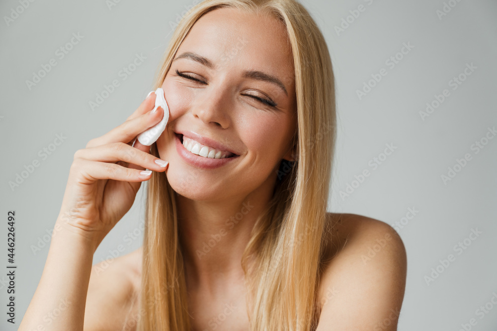 Half-naked blonde woman winking while using cotton pad Half-naked blonde woman winking while using cotton pad