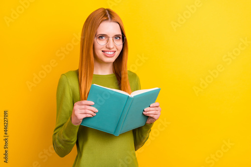 Photo of smart red hairdo millennial lady read book wear spectacles green sweater isolated on yellow color background