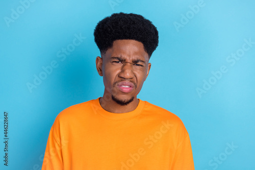 Photo of unhappy upset afro american disgusted man bad mood dislike isolated on pastel blue color background