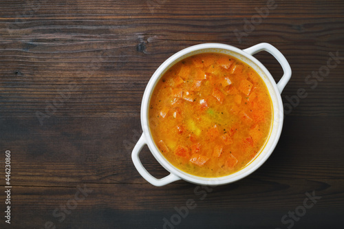 Bowl of soup on wood table background. Flat lay.