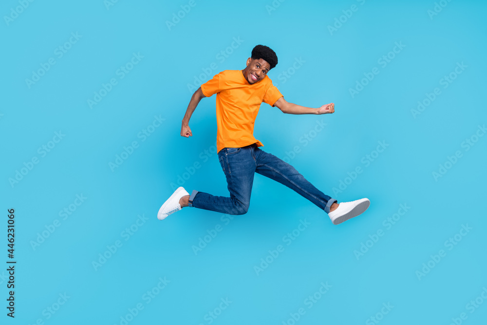Full length photo of happy dark skin cheerful young man jump up winner celebrate isolated on blue color background