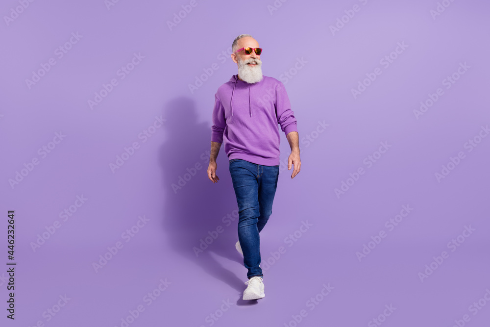Full length body size view of attractive cheerful grey-haired man going isolated over purple violet color background Full length body size view of attractive cheerful grey-haired man going isolated over purple violet color background