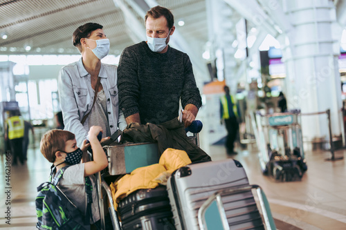 Family of three walking at airport in pandemic