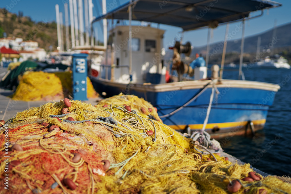 Fishing net on the seashore. Harbor with moored boats.