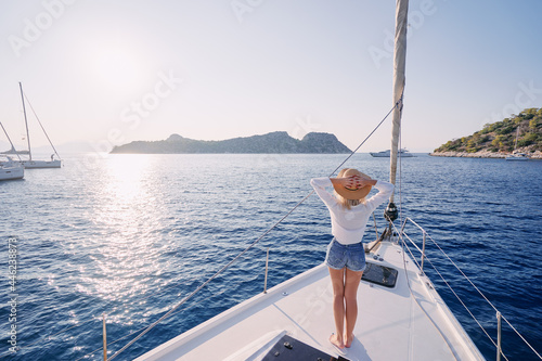Luxury travel on the yacht. Young happy woman on boat deck sailing the sea. Yachting in Greece. © luengo_ua