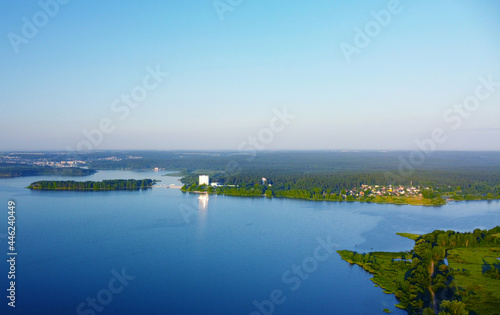 Aerial view of green shore of blue lake on summer morning © Payllik