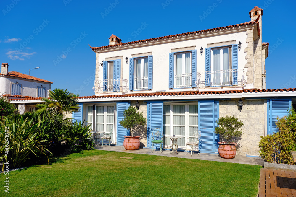 Fototapeta premium Aegean or Mediterranean type luxury stone villa exterior with blue shutters