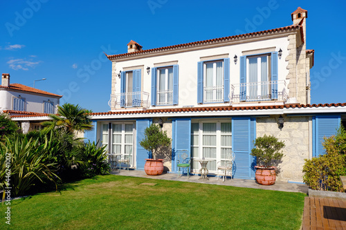 Aegean or Mediterranean type luxury stone villa exterior with blue shutters