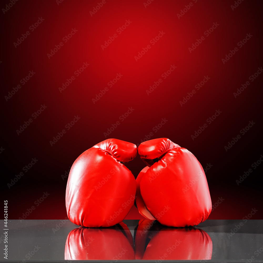 Boxing gloves on desk and red wall 