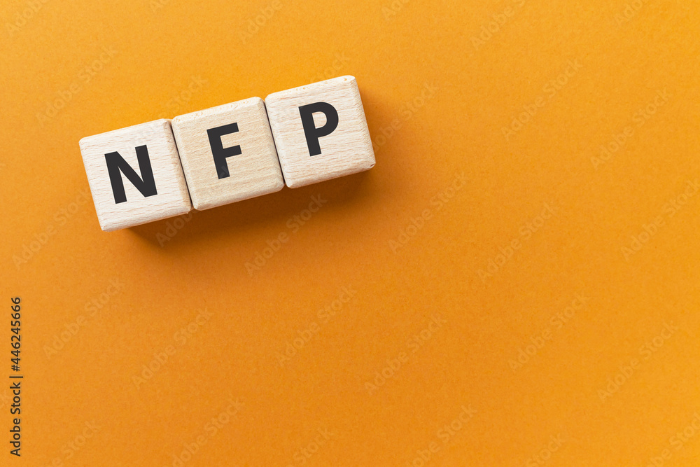 Text NFP on wooden cubes on bright orange ocher background. Abbreviation from 'Non-farm payrolls'. Nonfarm payroll employmen. Square wood blocks. Top view, flat lay. Text NFP on wooden cubes on bright orange ocher background. Abbreviation from 'Non-farm payrolls'. Nonfarm payroll employmen. Square wood blocks. Top view, flat lay.