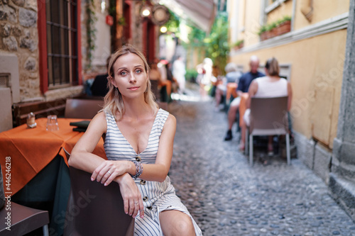 Young woman in sidewalk cafe on old town europian street.