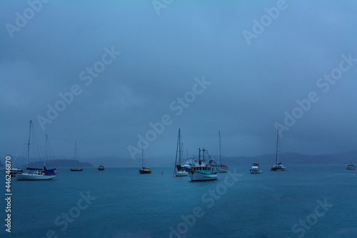 Heavy rain softens the lines of pleasure and fishing boats anchored in a small harbour